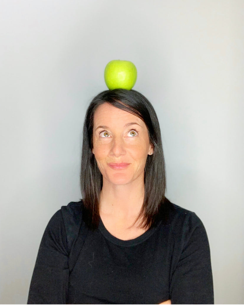 Nutritional Consultant Allison Tannis standing with green apple on her head